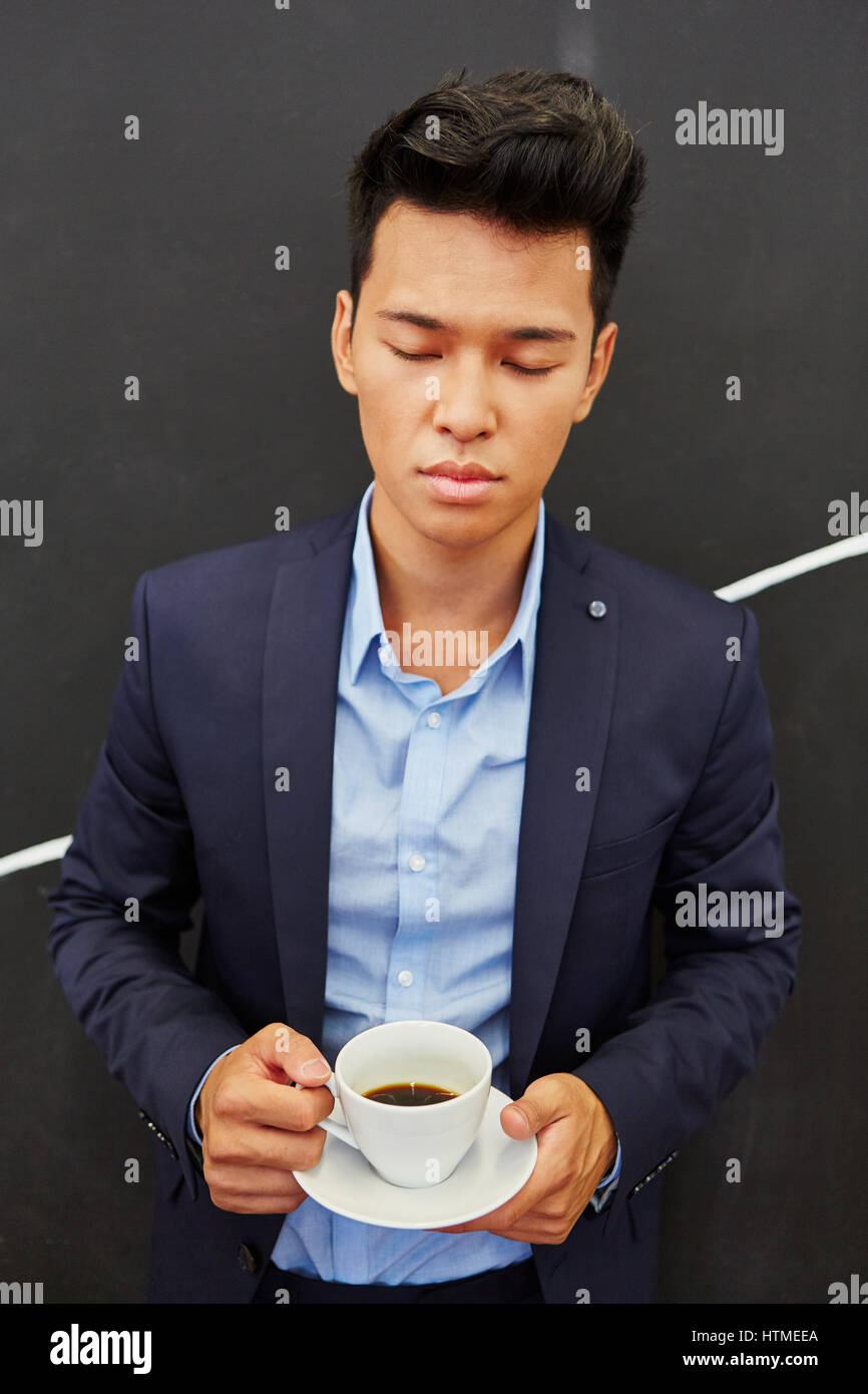Asian businessman takes coffee break for relaxation outside Stock Photo