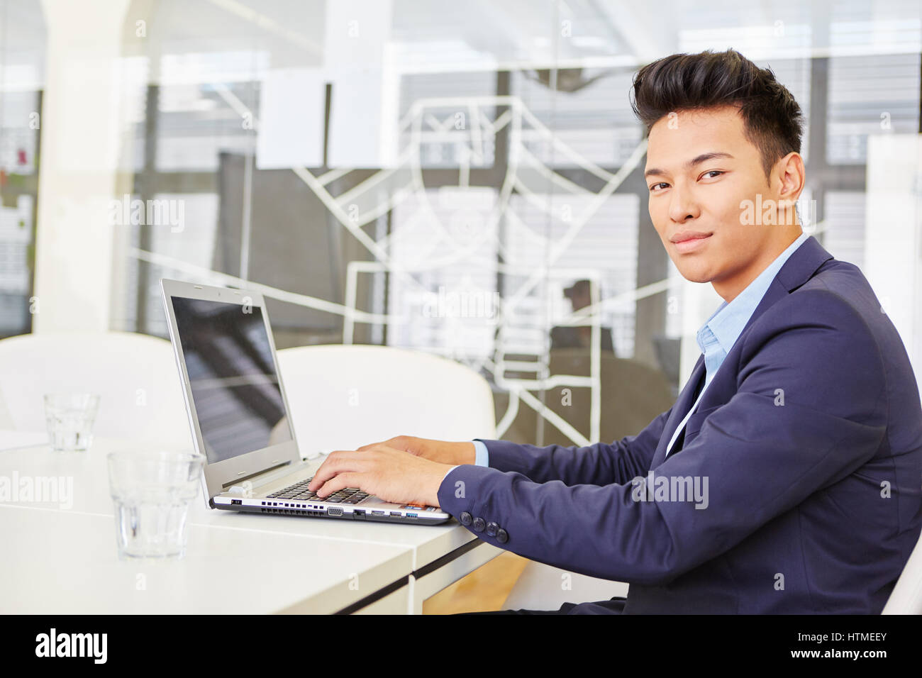 Asian man as expert programmer with laptop computer Stock Photo