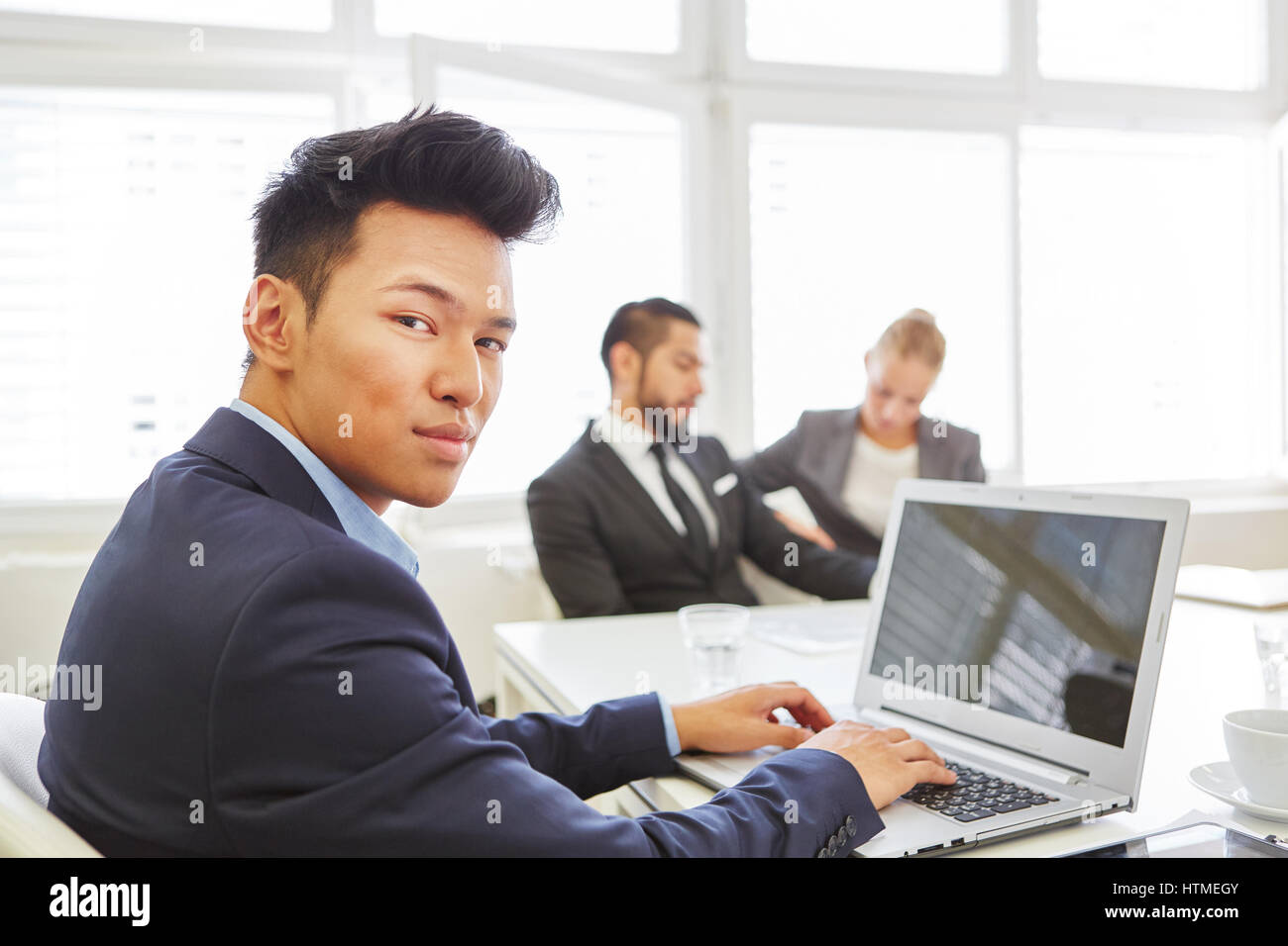 Asian man as competent programmer using laptop computer in the office Stock Photo