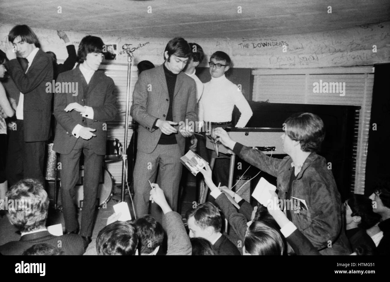 Charlie Watts and Bill Wyman, members of the Rolling Stones, signing autographs on the stage of the Golf-Drouot in Paris in 1965. Stock Photo