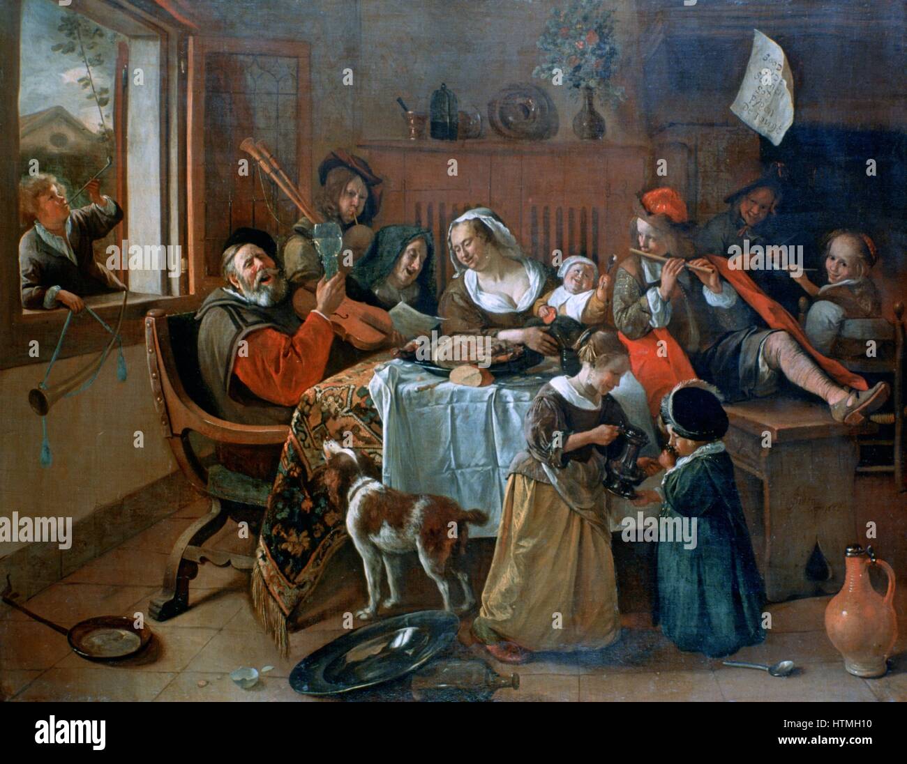 The Merry Family': Dutch interior showing a family making music round a table covered in a carpet and a cloth with the remains of a meal. Even the dog seems to be joining in. The patriarch puts his instrument aside and raises his glass in a toast. The wom Stock Photo