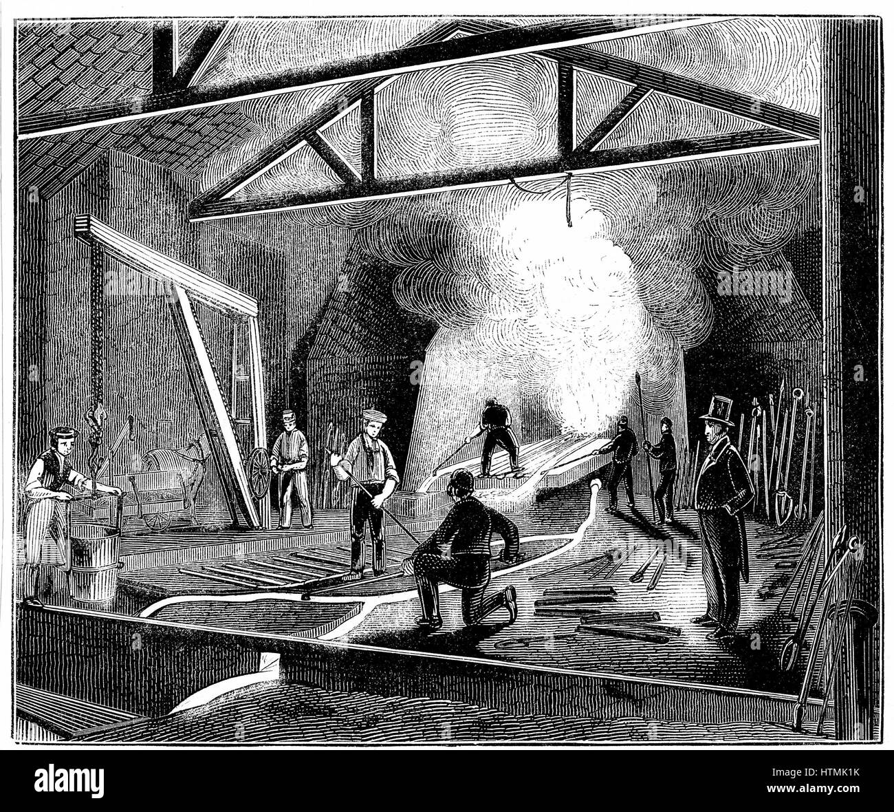 The foundry or cast house, Butterley Ironworks, Derbyshire. Tapping the furnace and casting iron into 'pigs'. Manager in top hat and tail coat watches the procedure. Wood engraving 1844 Stock Photo