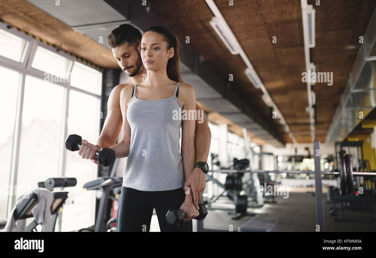 Personal trainer helping woman reach goals in gym Stock Photo - Alamy