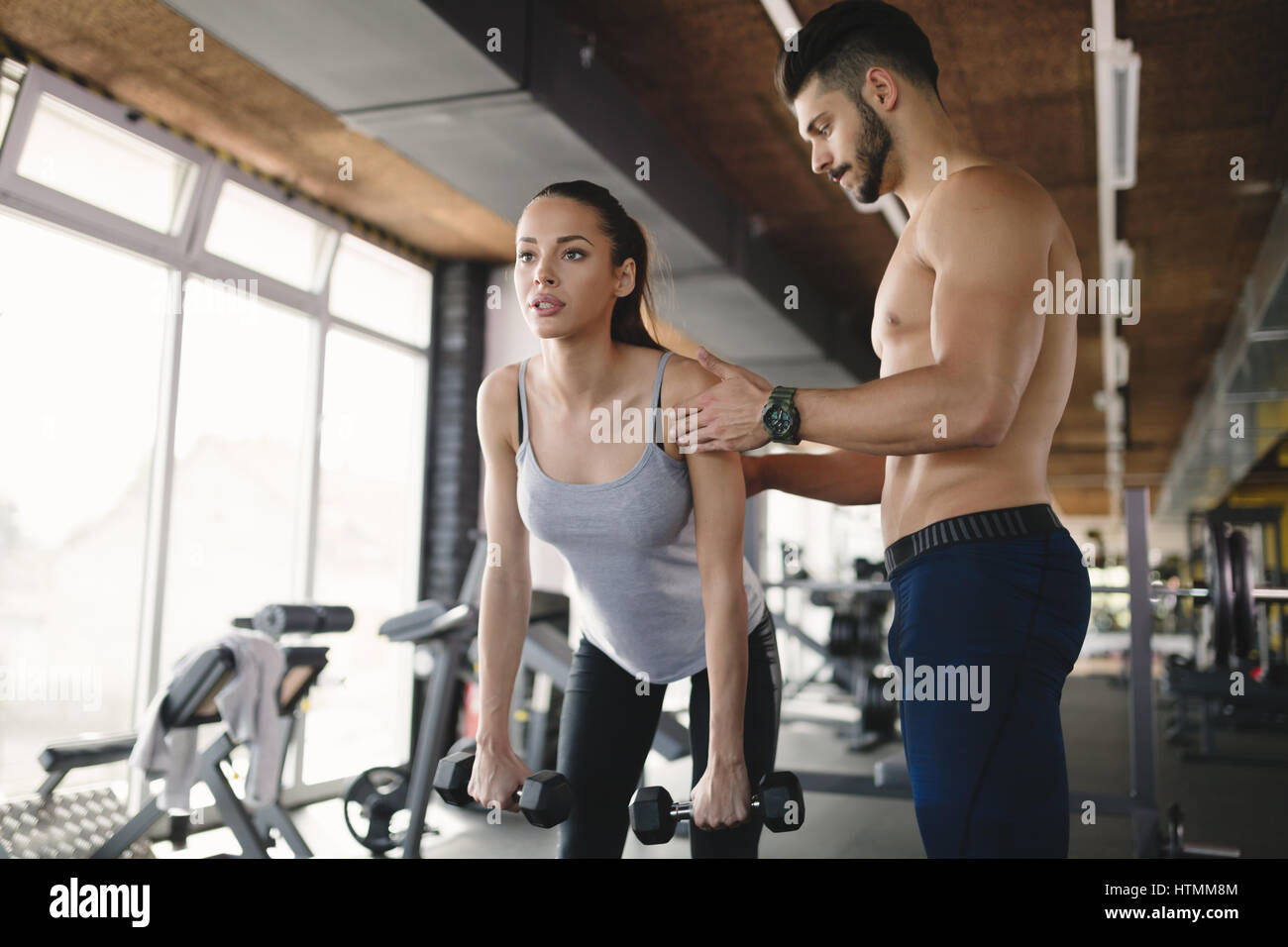 Personal trainer helping woman reach goals in gym Stock Photo - Alamy