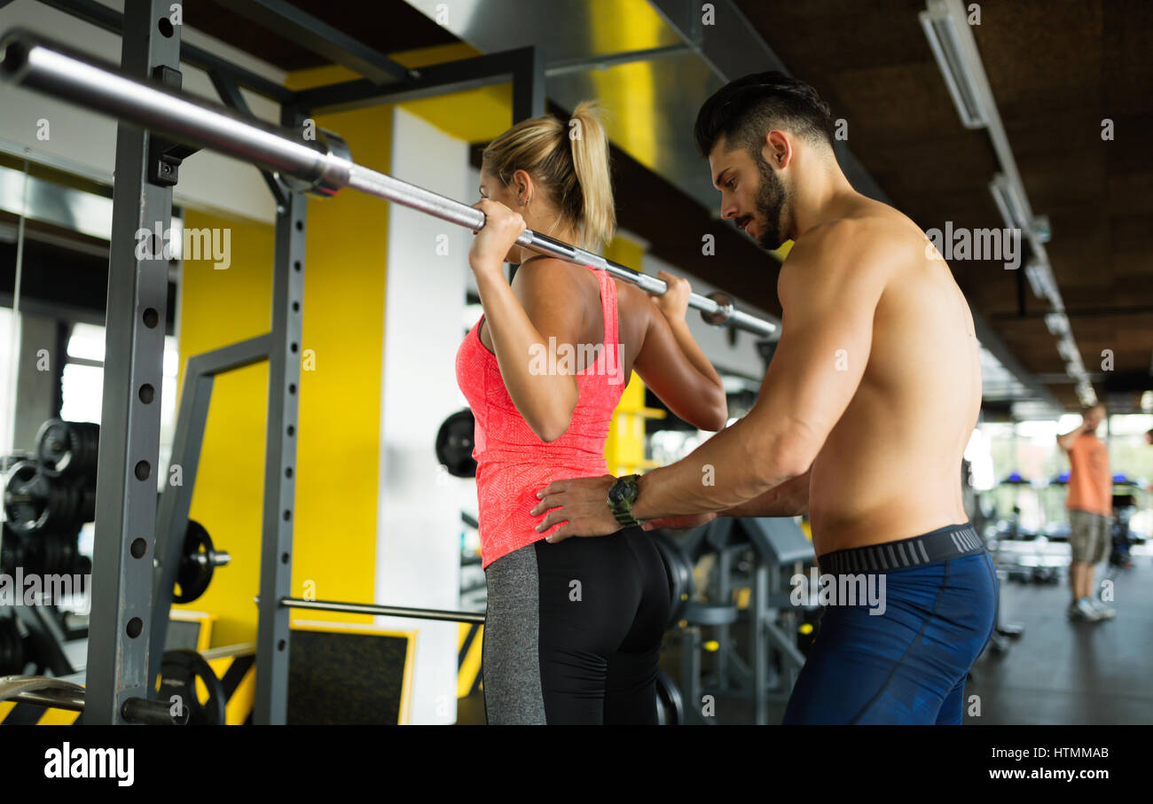 Personal trainer helping woman reach goals in gym Stock Photo - Alamy