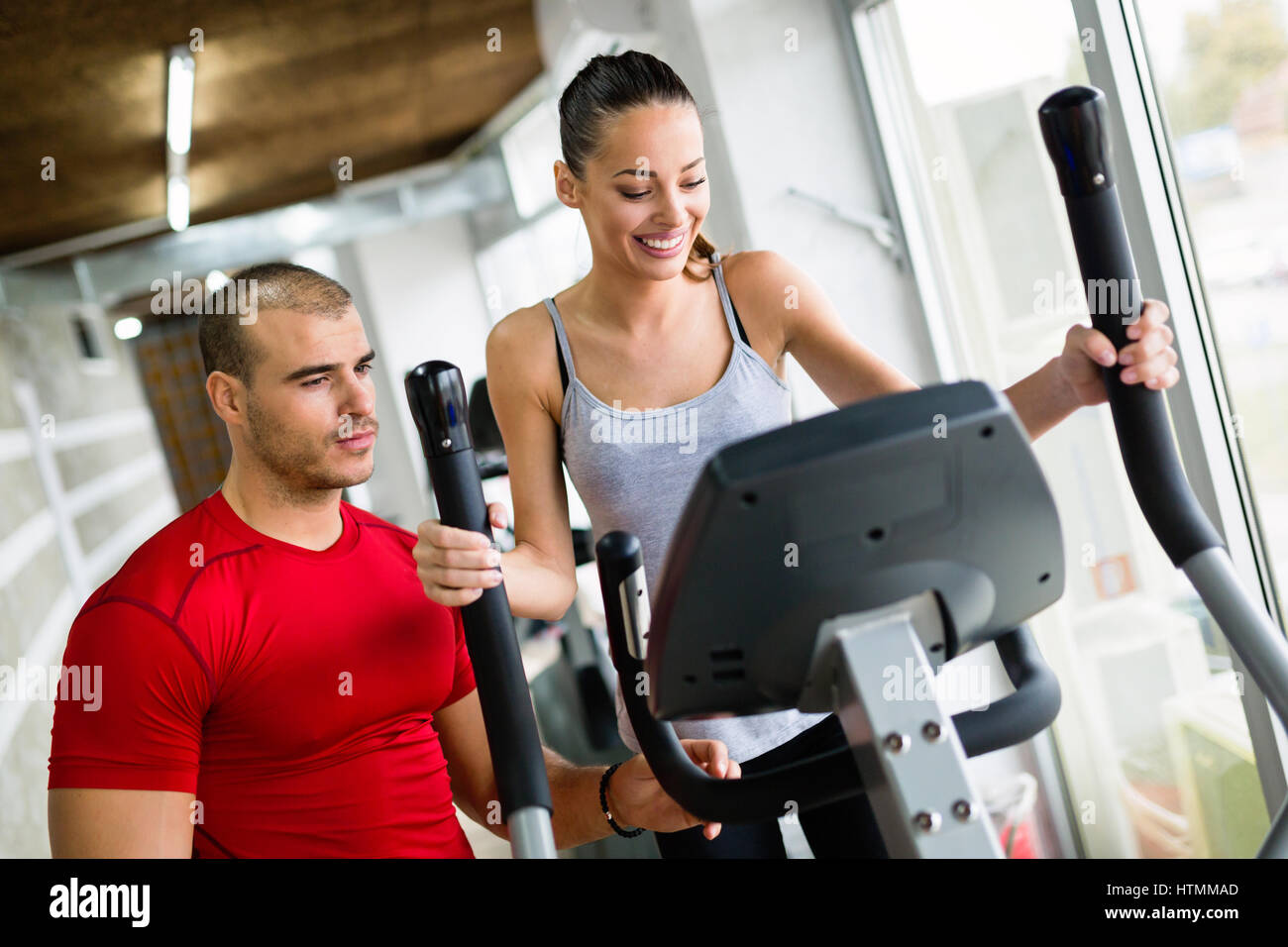 Personal trainer helping woman reach goals in gym Stock Photo - Alamy