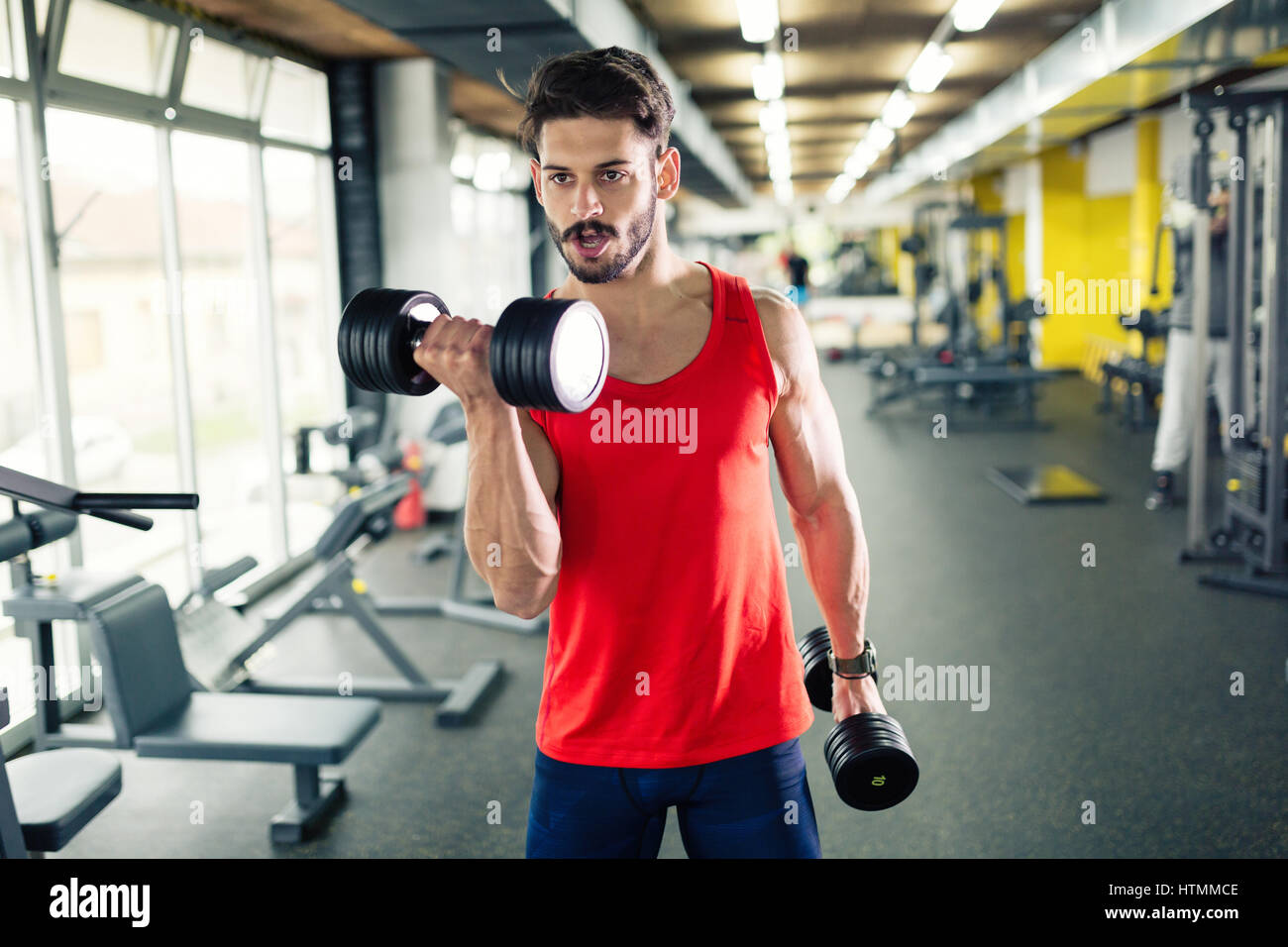 Determined male working out in gym lifting weights Stock Photo Alamy