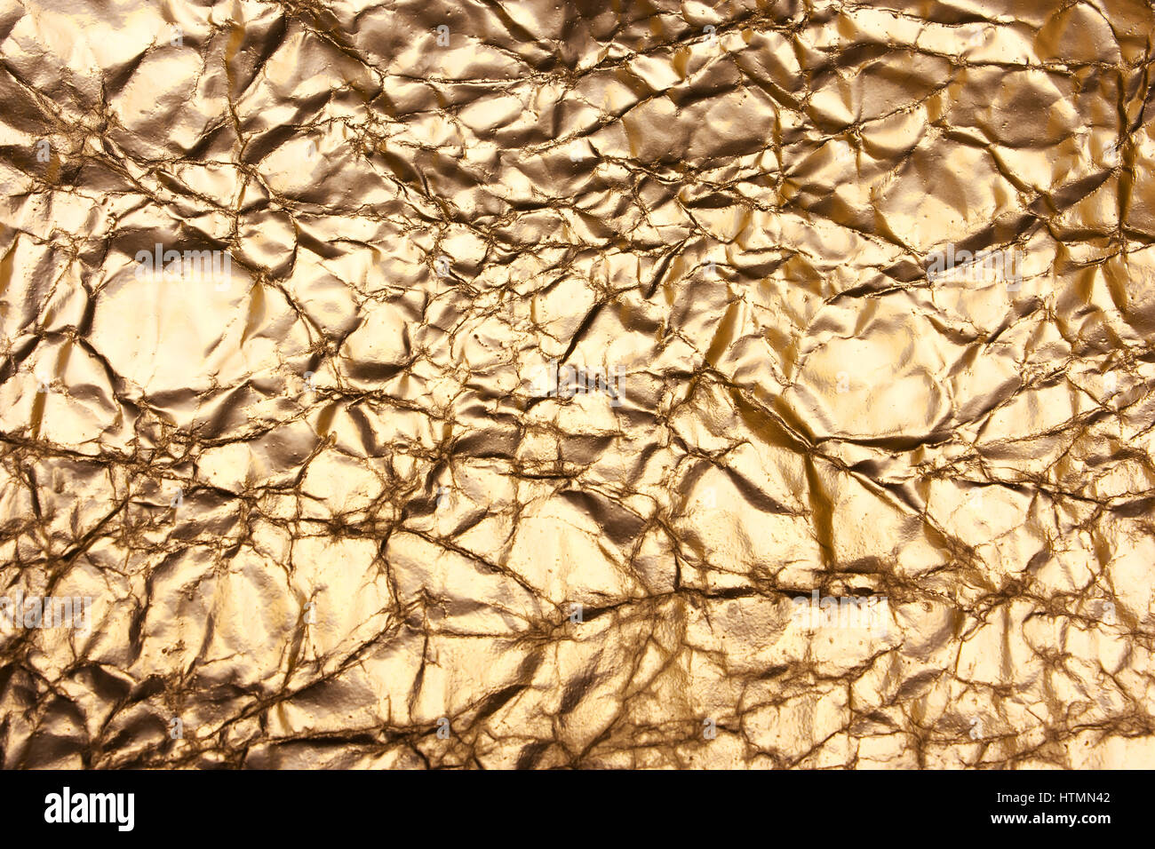 Golden background, shiny creased paper, antique, vintage backdrop. Bronze texture Stock Photo