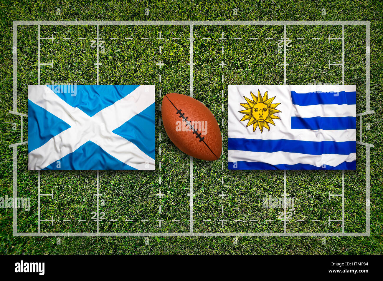 Scotland vs. Uruguay flags on green rugby field Stock Photo