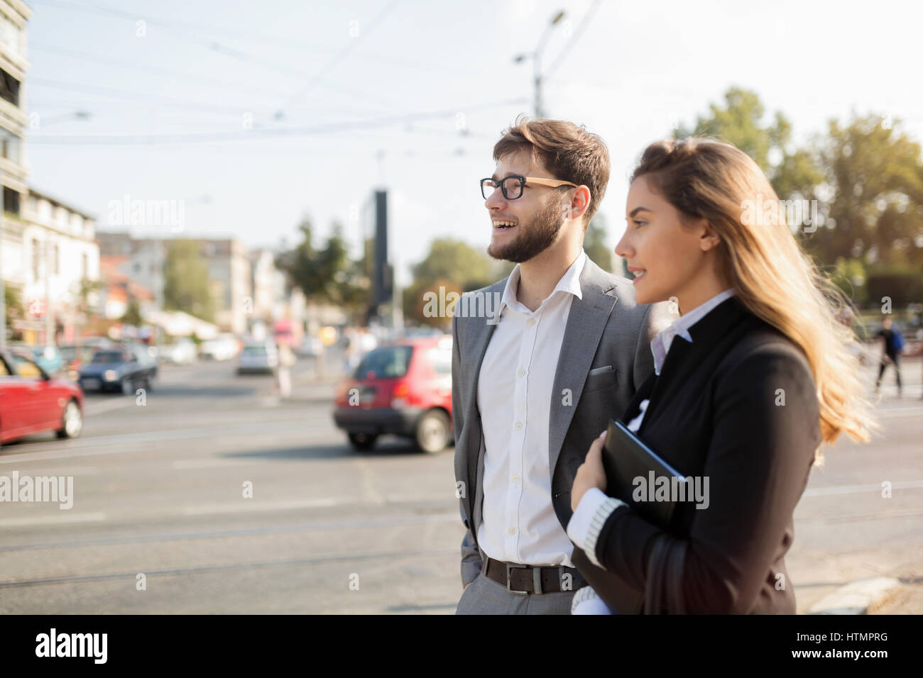 Happy business people walking in city and smiling Stock Photo - Alamy