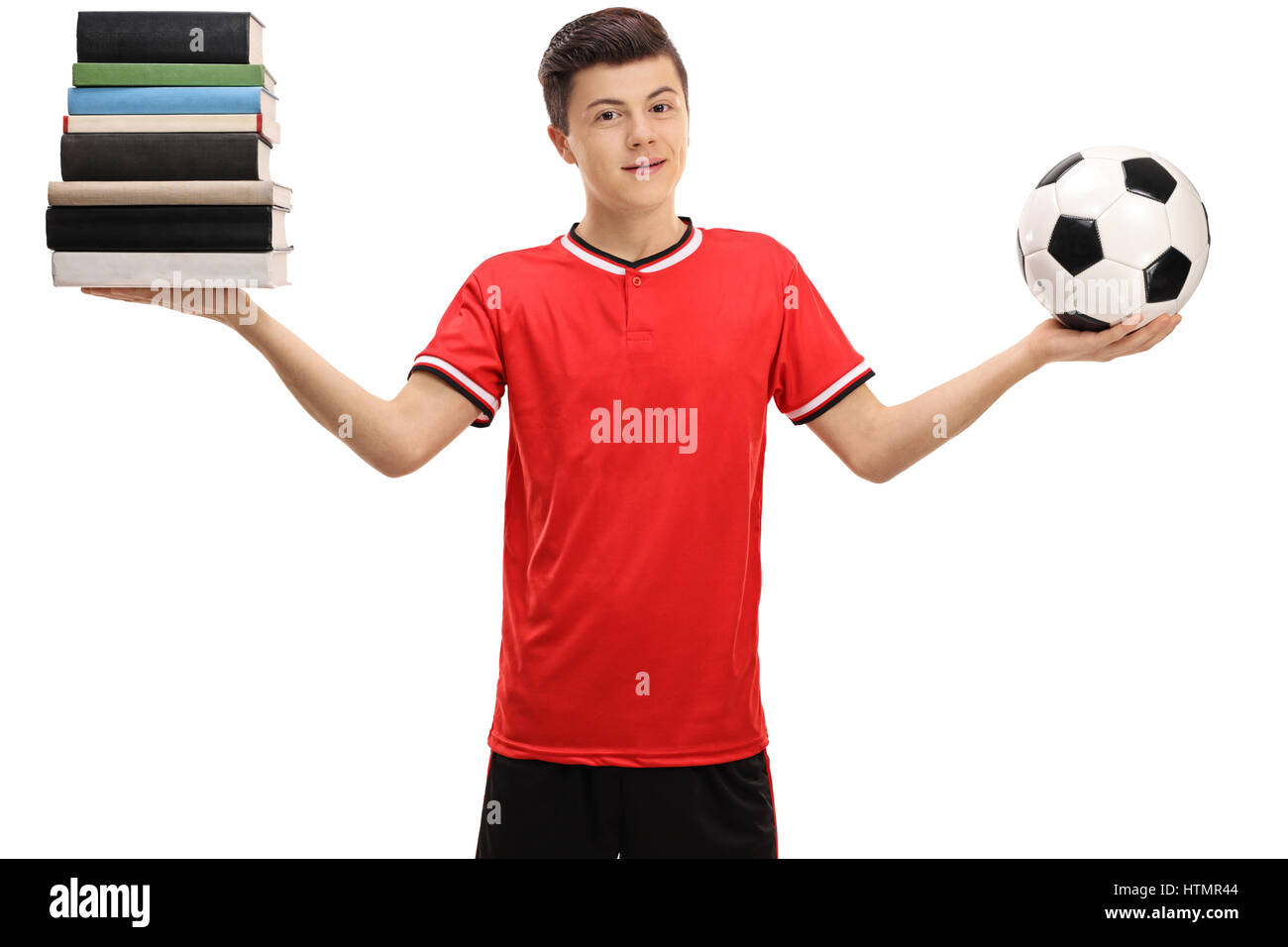 Teenage boy holding a stack of books and a football isolated on white background Stock Photo