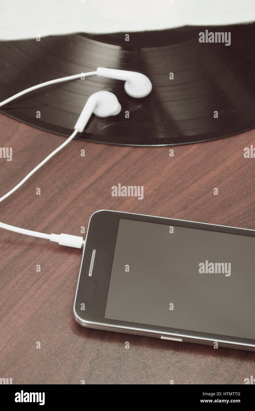 smartphone with earbuds on vinyl record Stock Photo