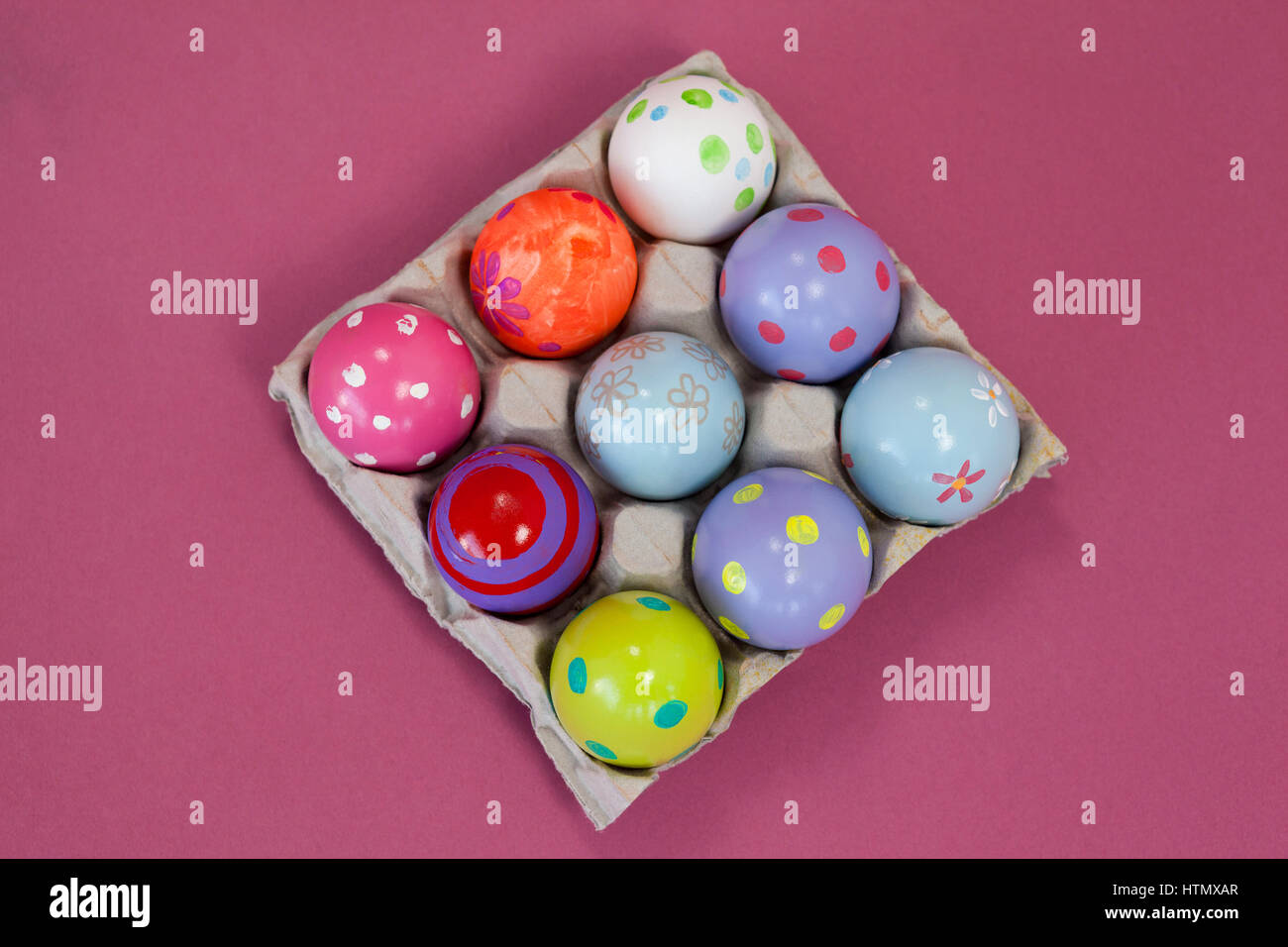 Colorful Easter eggs in egg carton on pink background Stock Photo - Alamy