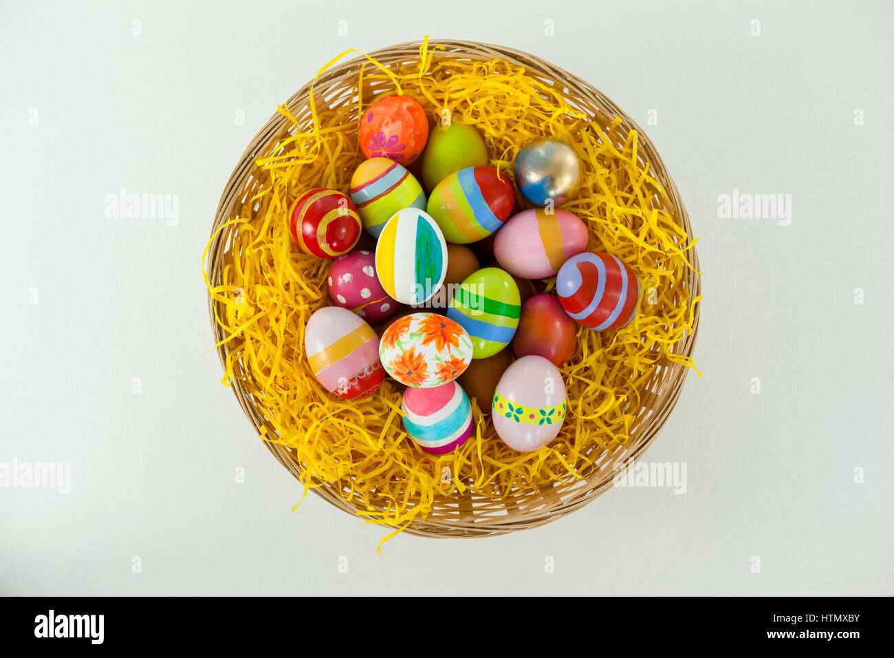 Painted easter eggs in basket against white background Stock Photo - Alamy
