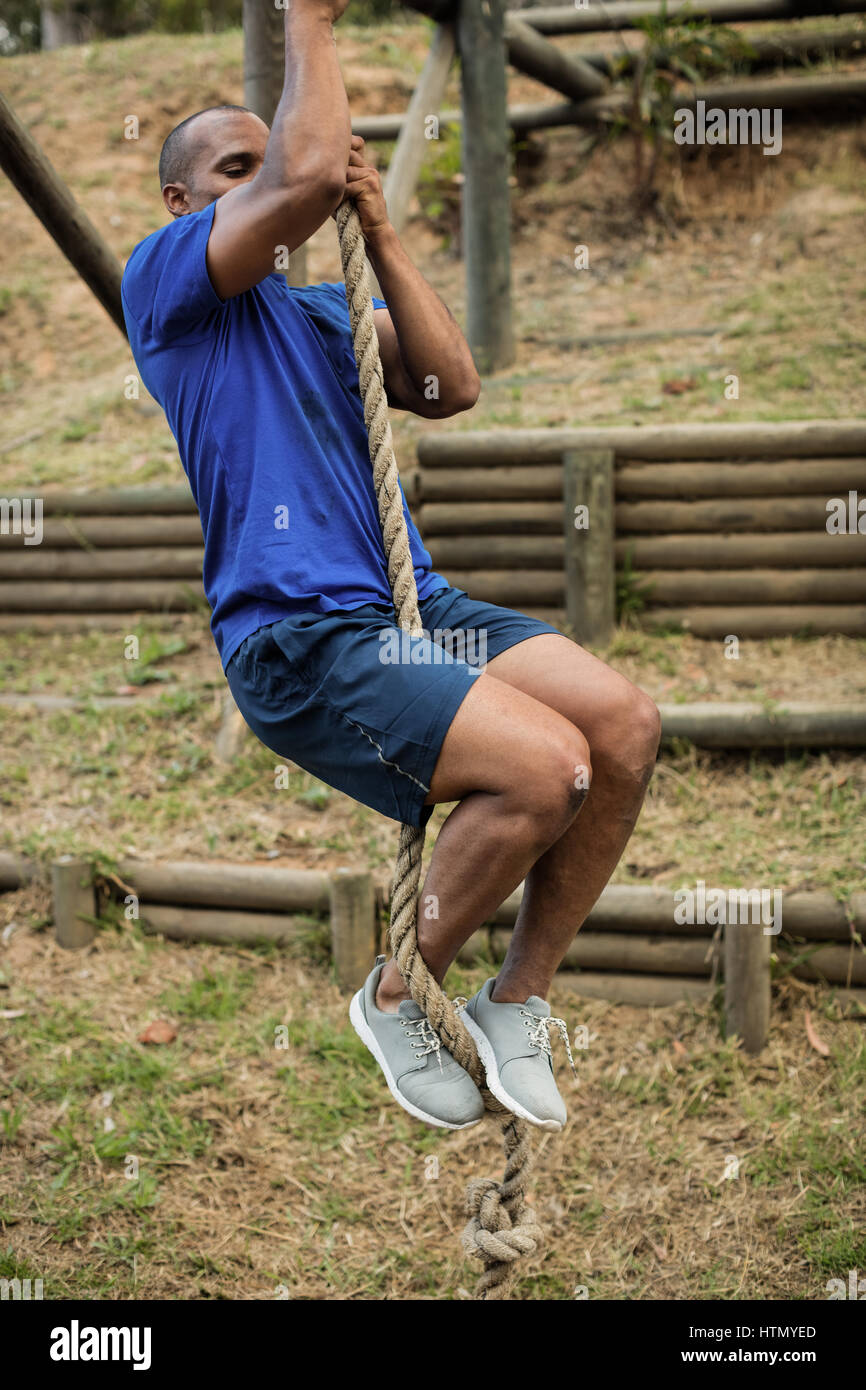 Man climbing rope during obstacle hi-res stock photography and images ...