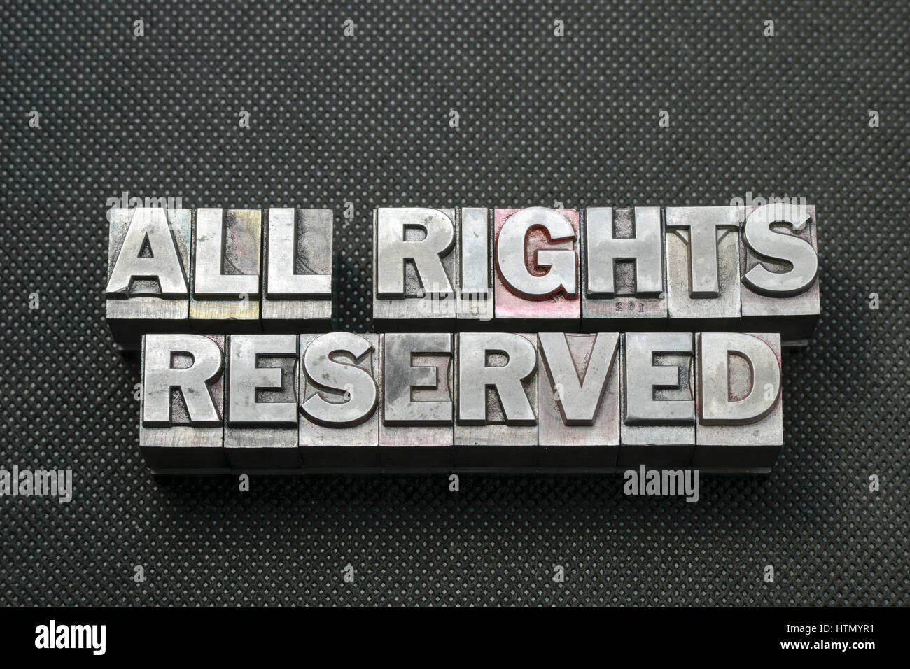 all rights reserved phrase made from metallic letterpress blocks on black perforated surface Stock Photo