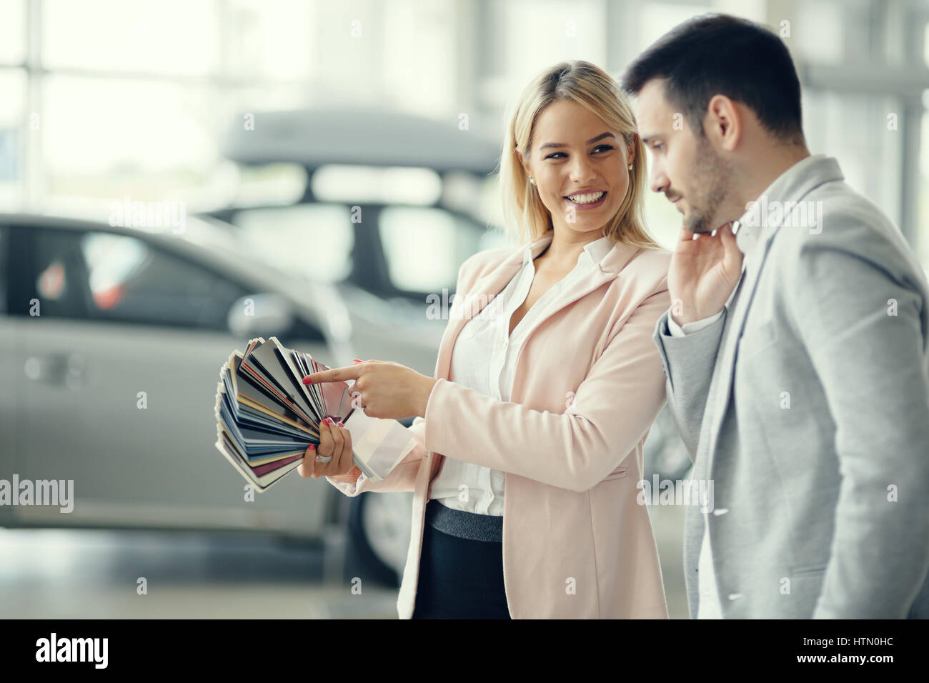 Customer choosing car color at dealership Stock Photo