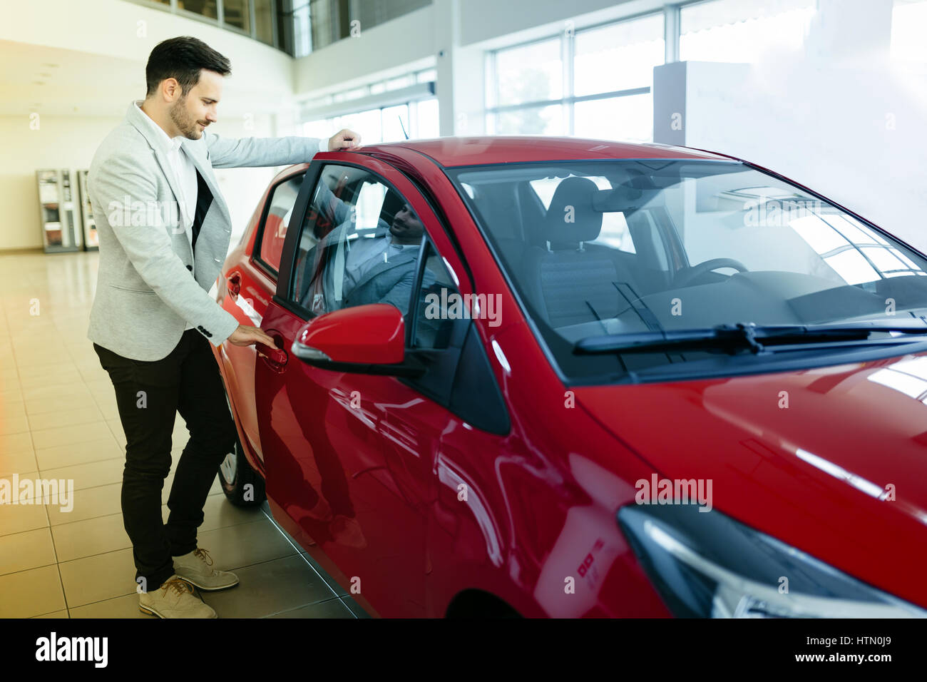 Handsome customer buying car at dealership Stock Photo Alamy