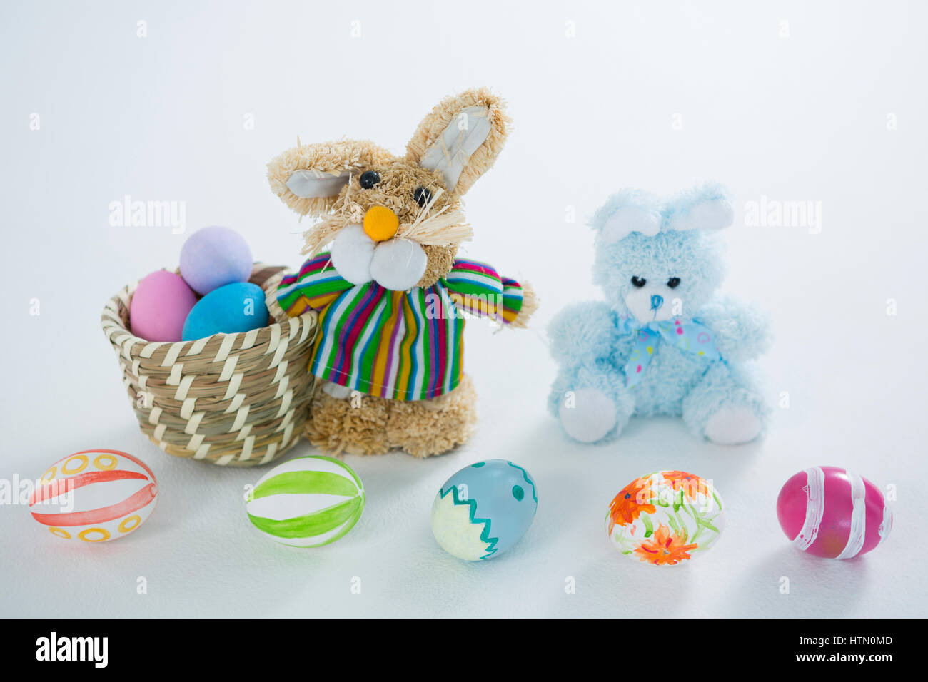 Basket with Easter eggs and toy Easter bunny on white background Stock ...