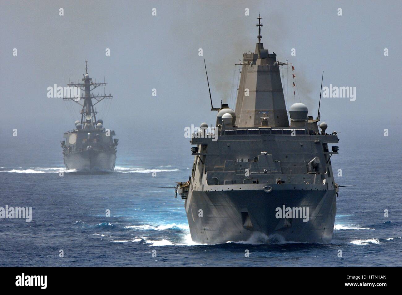 The USN San Antonio-class amphibious transport dock ship USS New York (front) and the USS Arleigh Burke-class guided-missile destroyer USS Porter steam in formation June 10, 2012 in the Strait of Hormuz. Stock Photo