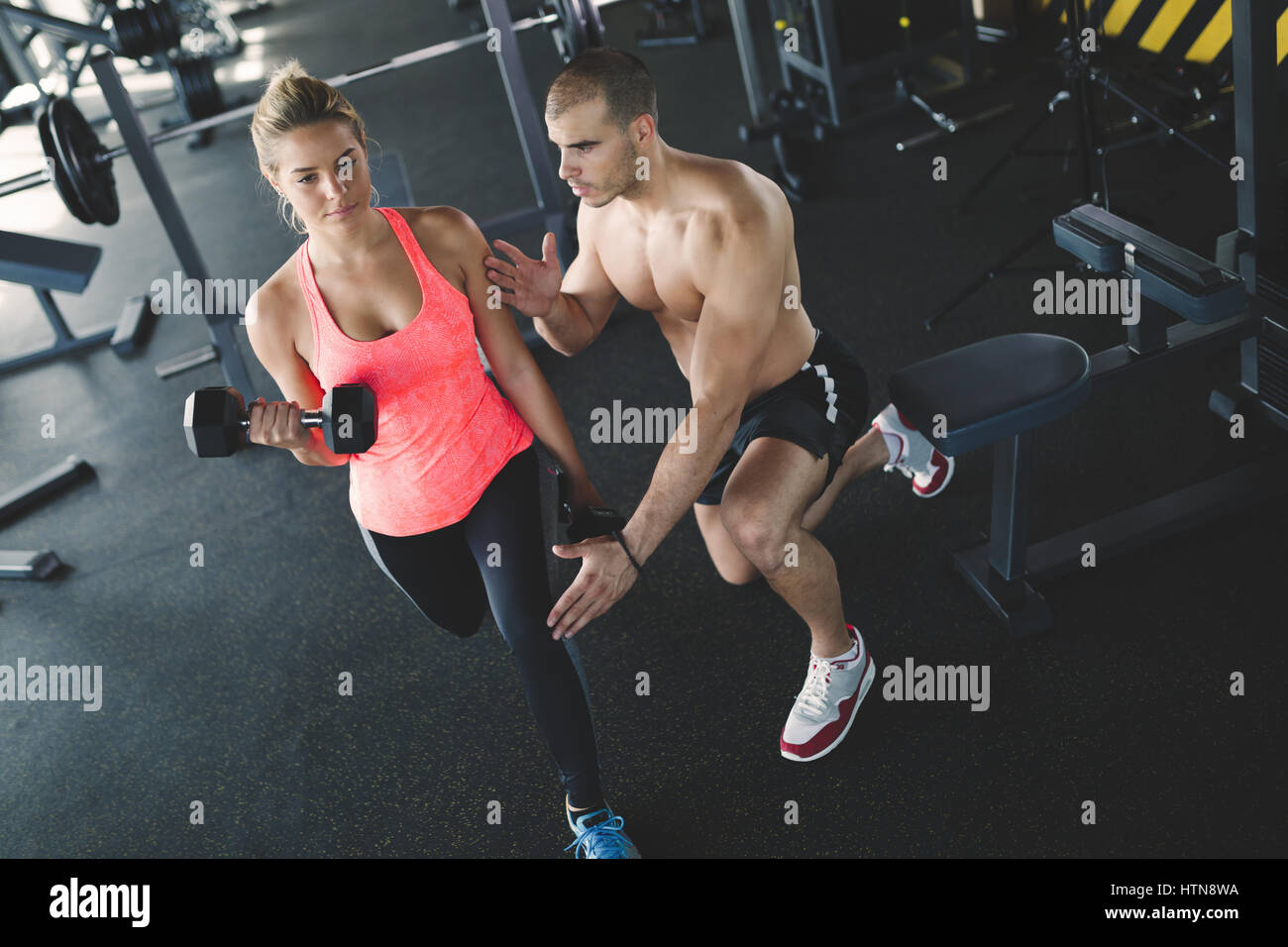 Personal trainer helping woman reach goals in gym Stock Photo - Alamy