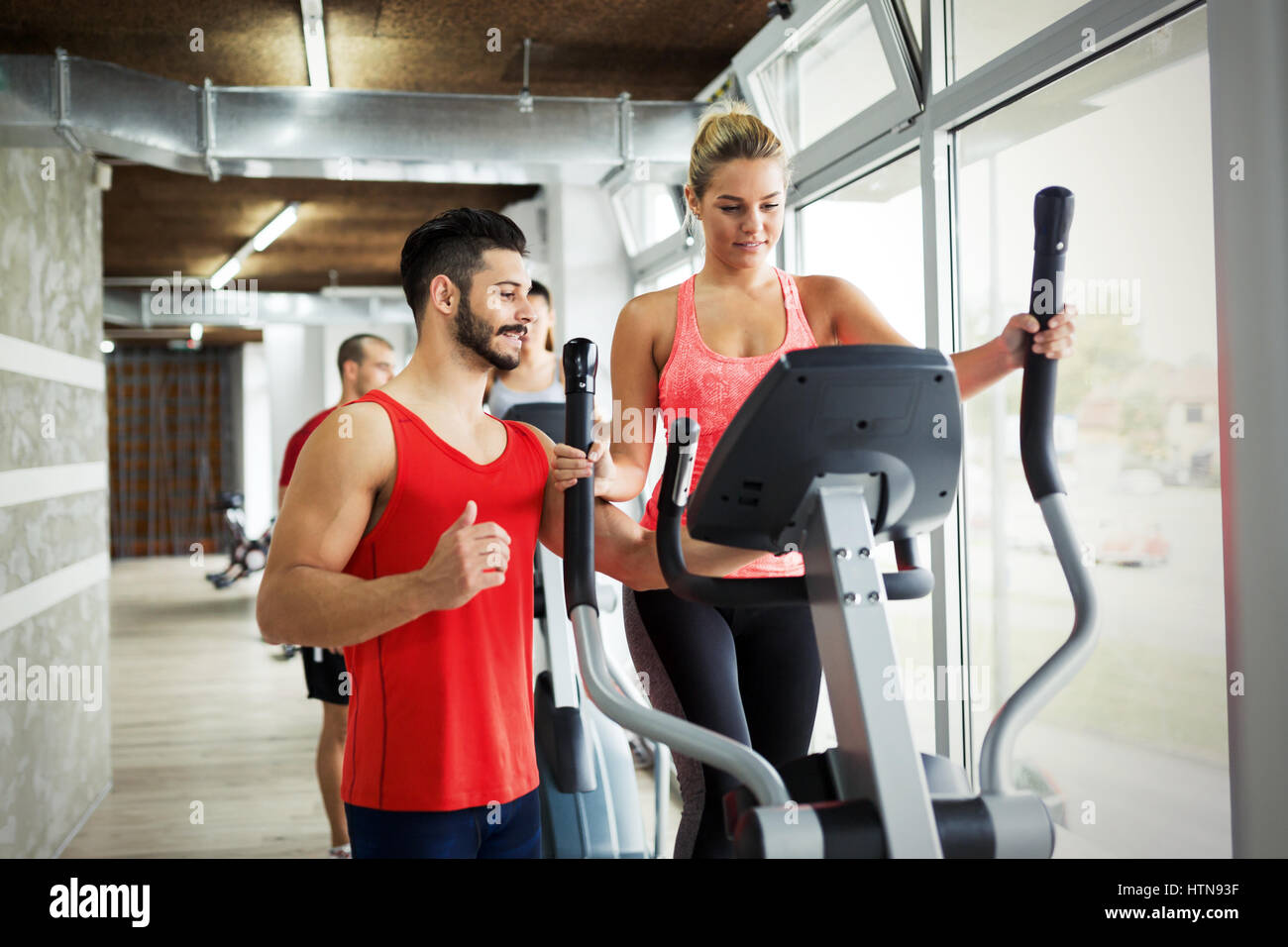Personal trainer helping woman reach goals in gym Stock Photo - Alamy