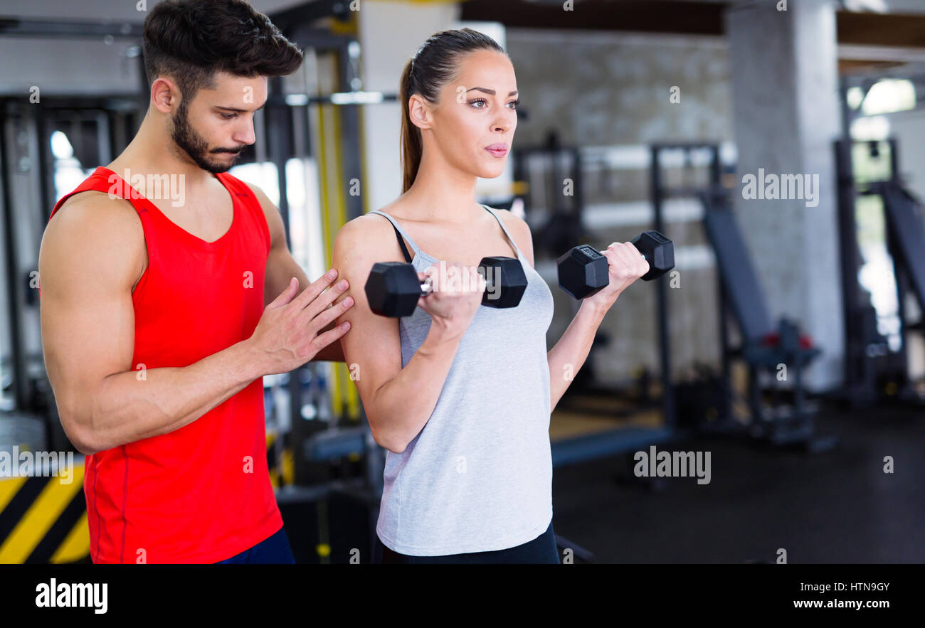 Personal trainer helping woman reach goals in gym Stock Photo - Alamy