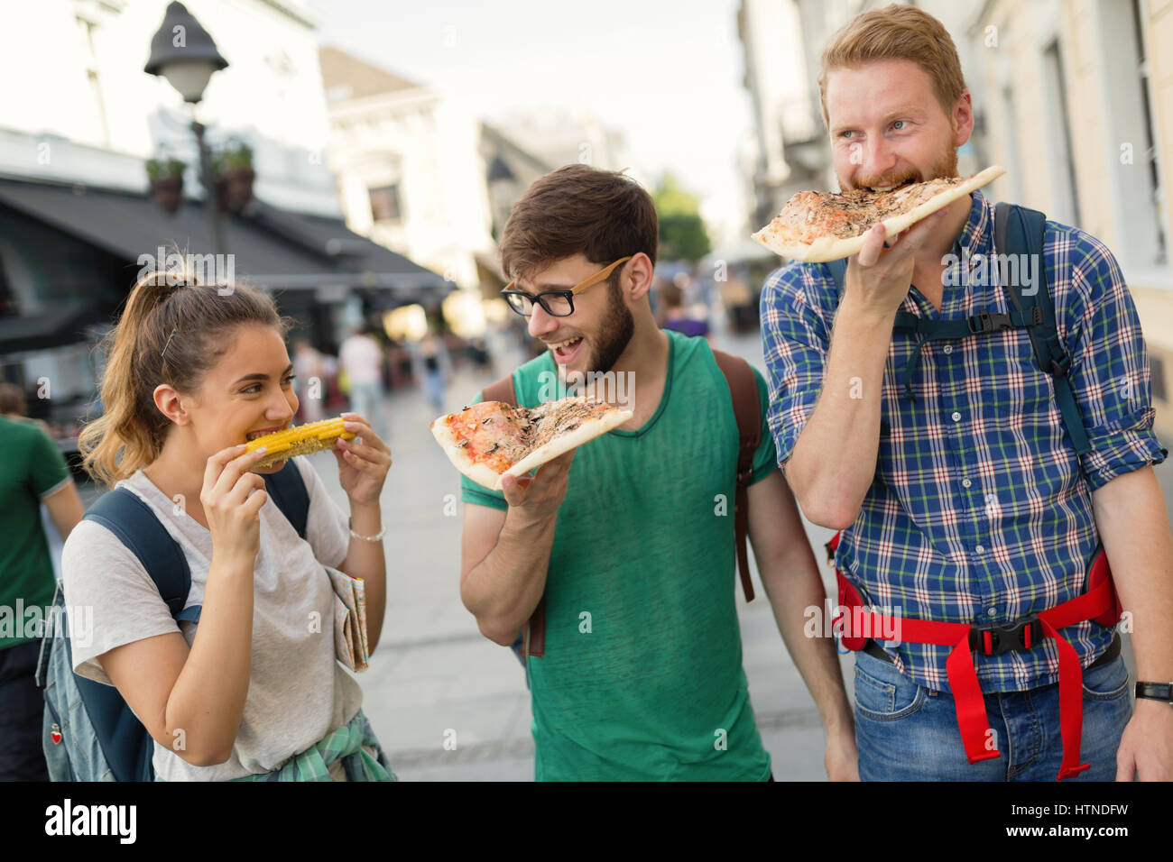 Happy group of friends eating pizza outdoors Stock Photo - Alamy