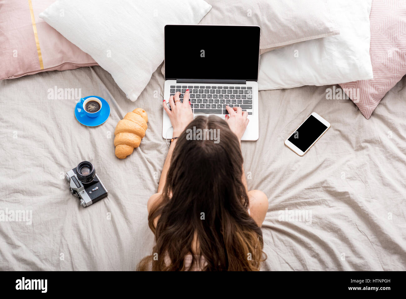 Woman with laptop on the bed Stock Photo - Alamy