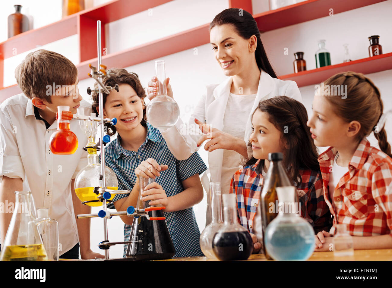 Interesting lesson. Cheerful positive cute children standing around the ...