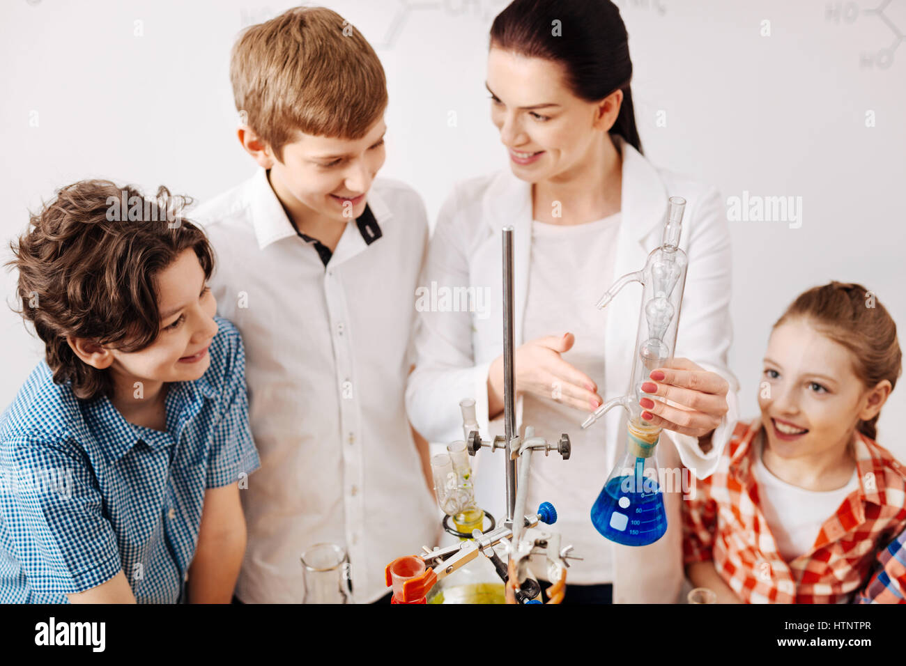 We love science. Delighted experienced female teacher holding a special ...