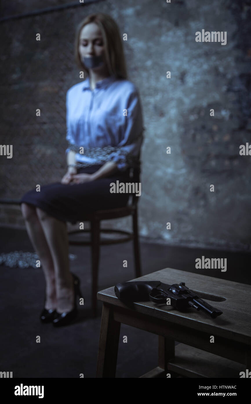 Why me. Clueless anxious business lady being captured for ransom while sitting on a chair and being tied up Stock Photo