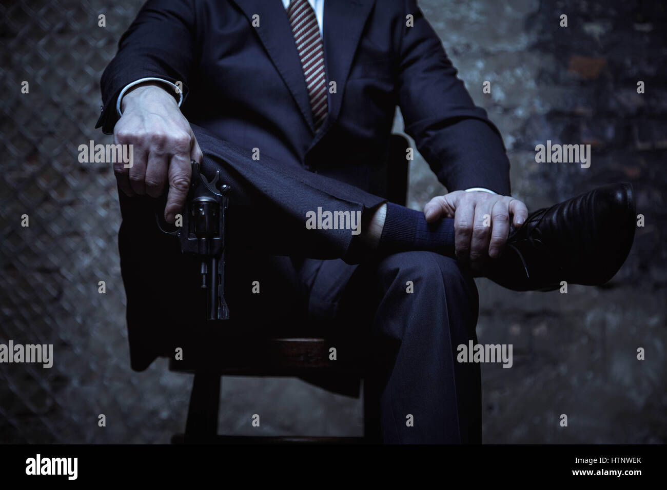 I can solve anything. Elegant evil handsome law violator demonstrating his  power by showing off his gun and wearing classic black suit Stock Photo -  Alamy
