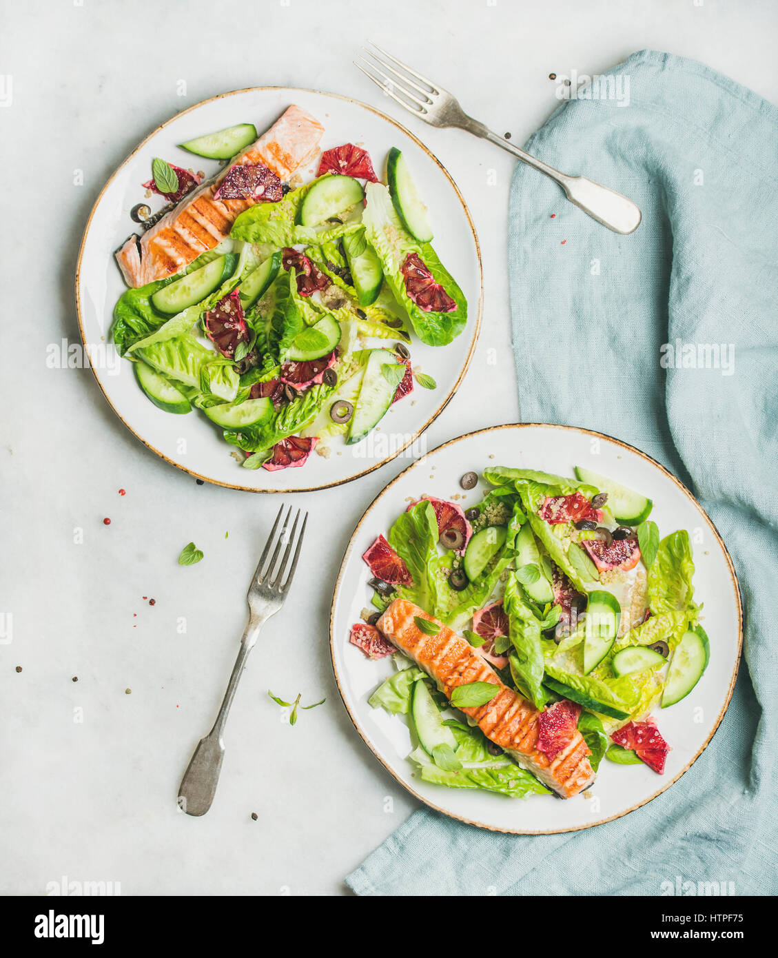 Healthy energy boosting spring salad with grilled salmon, blood orange, olives and quinoa, top view, marble background. Clean eating, dieting, detox, Stock Photo
