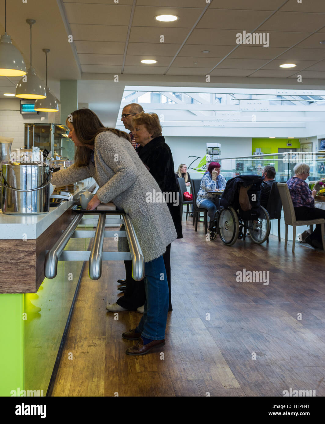 Female at the counter buying coffee and cakes in a Torquay restaurant café. Stock Photo