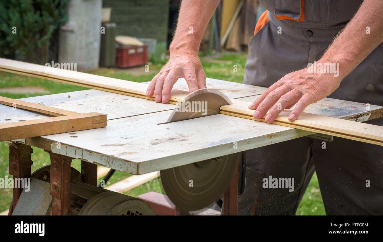 Carpenter working with electric buzz saw cutting wooden boards Stock Photo Alamy