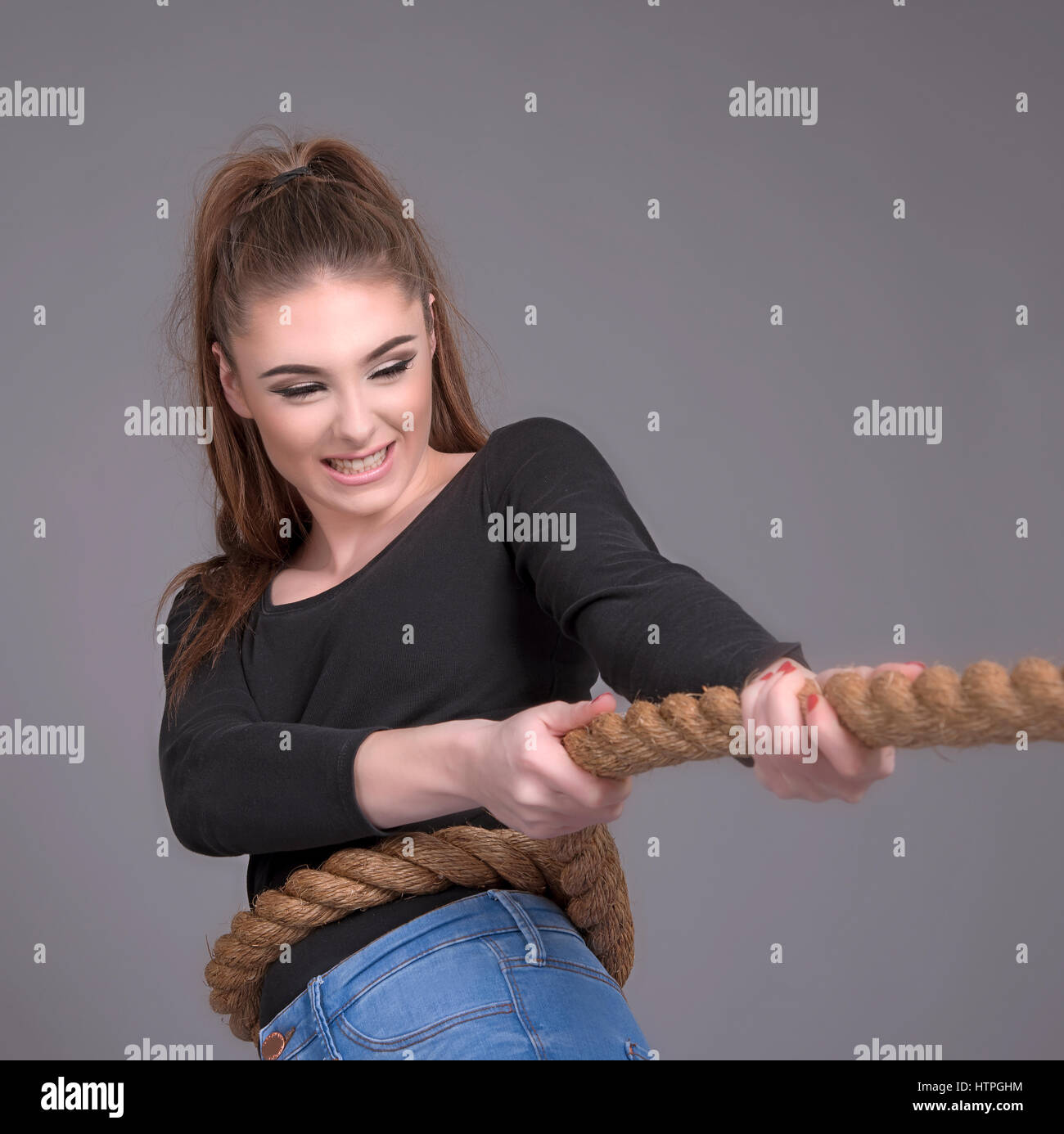 Young girl pulling on a rope Stock Photo