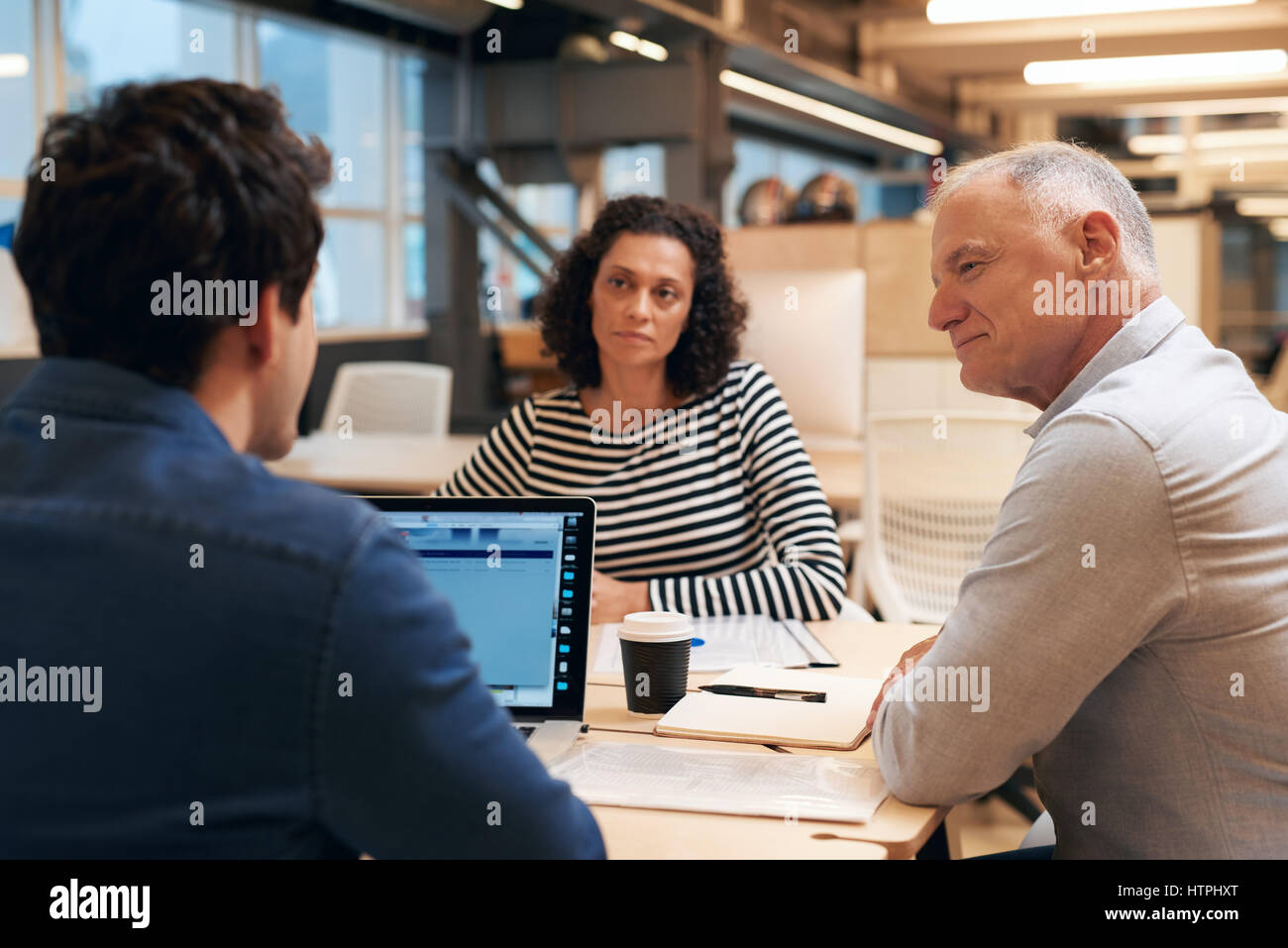 Diverse group of casually dressed professional colleagues talking ...