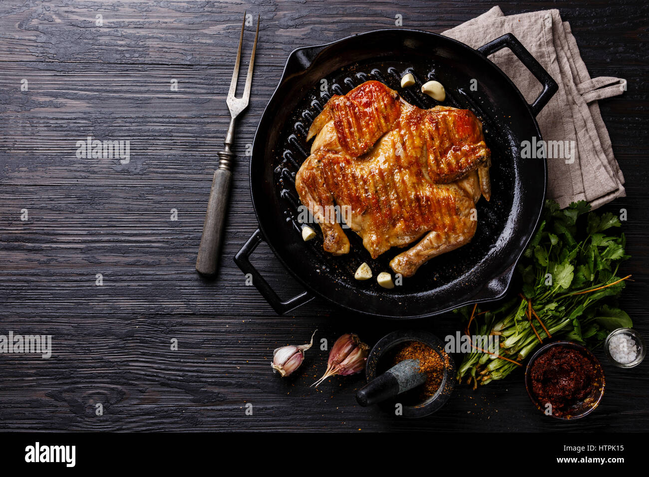 Grilled fried roast Chicken Tabaka in frying pan on wooden background copy space Stock Photo