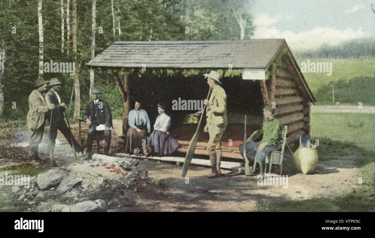 Postcard of men and women gathered at an open camp in the Adirondacks, New York, 1914. From the New York Public Library. Stock Photo