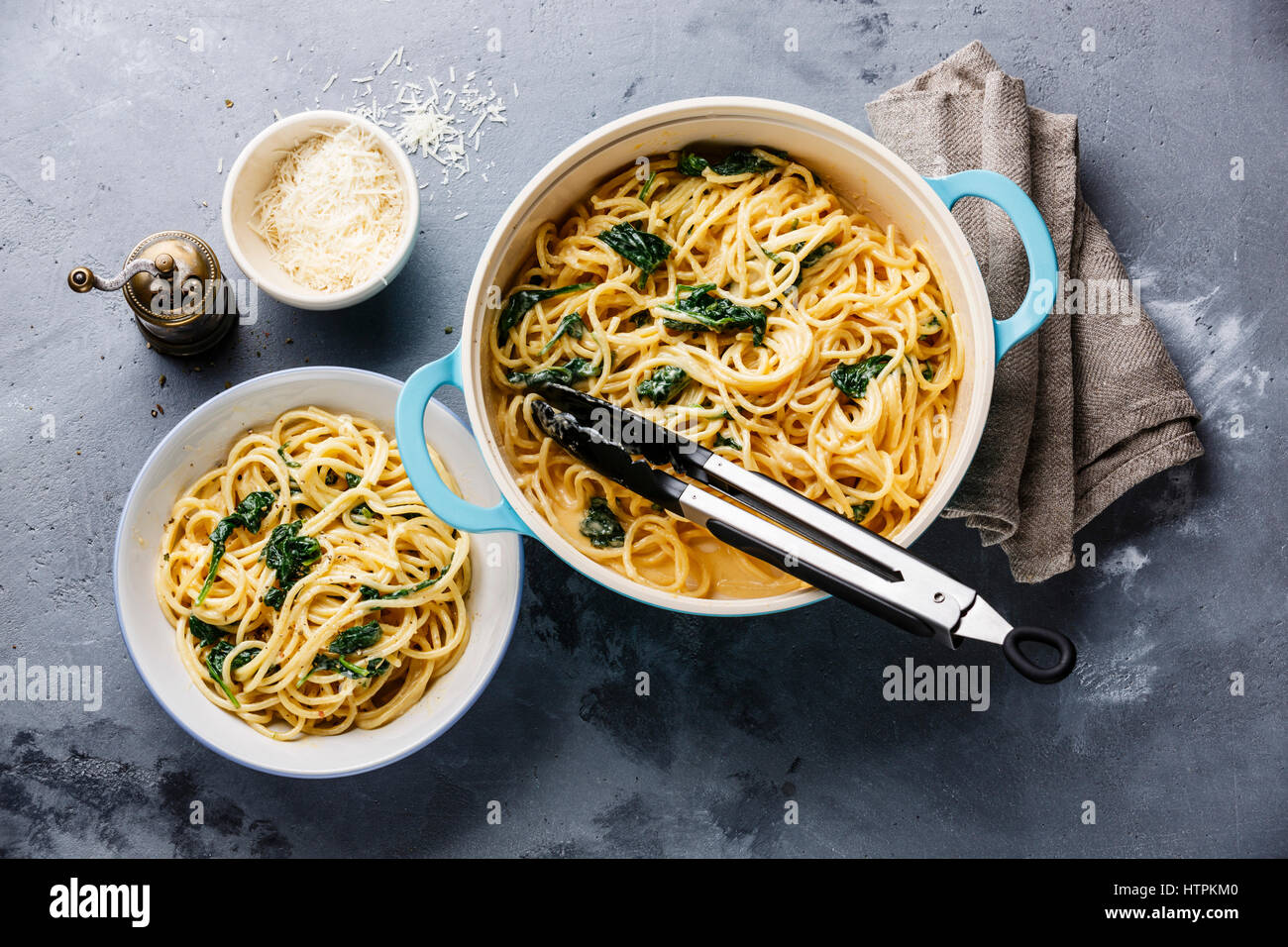 Spaghetti with Spinach and cream sauce in pan on gray concrete background Stock Photo