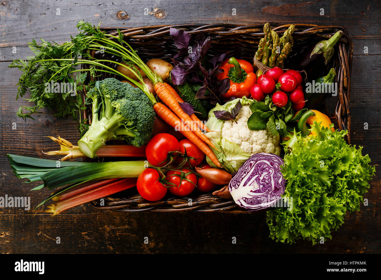 Fresh vegetables in basket on wooden background Stock Photo - Alamy