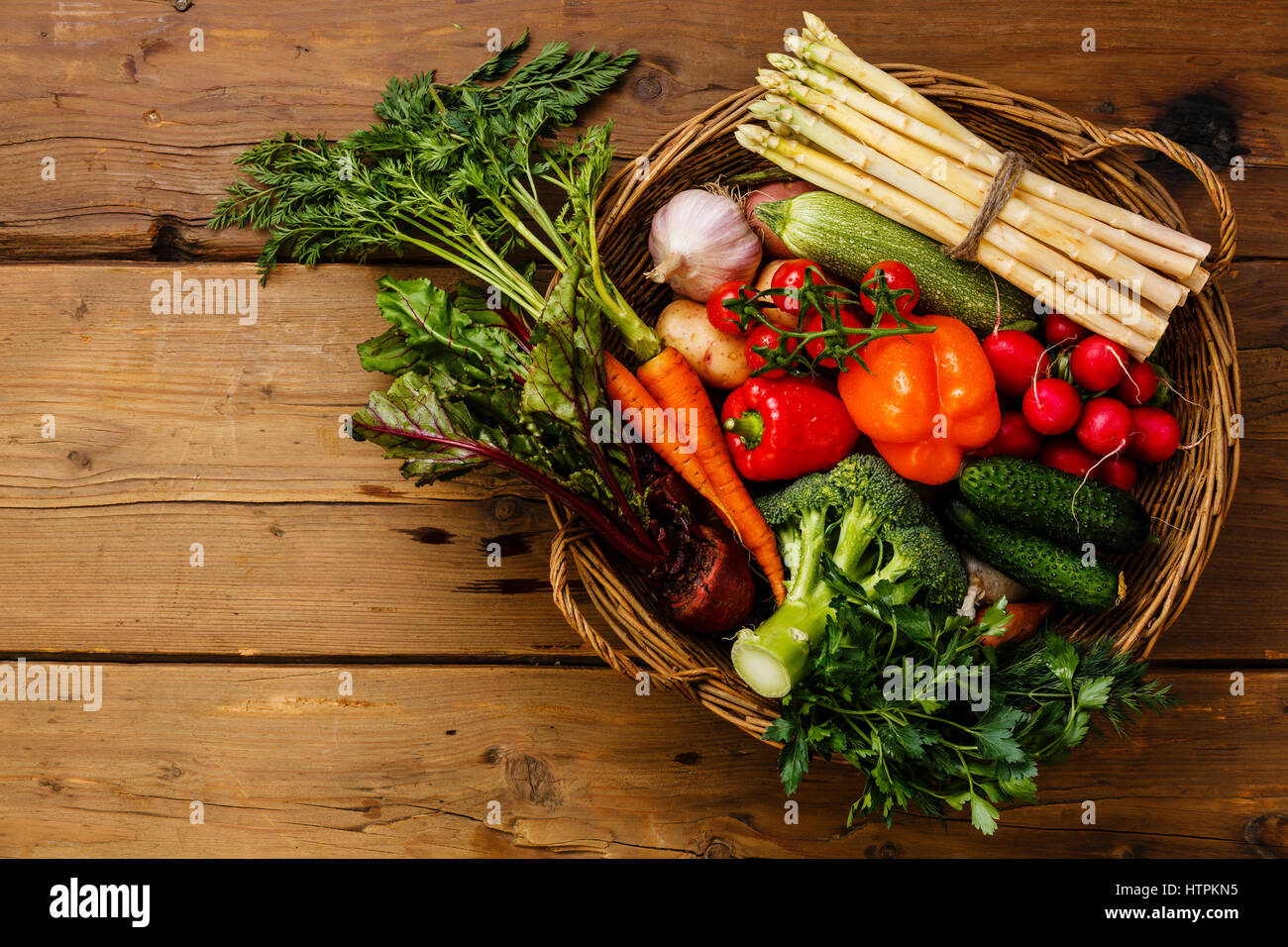 Fresh vegetables in basket on wooden background Stock Photo