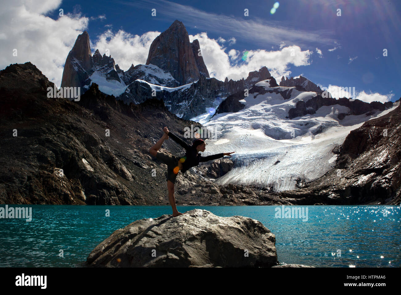 A young fit woman in a Lord of the Dance Yoga Pose with Monte Fitz Roy at the background in Los Glaciares National Park in Patagonia, Argentina Stock Photo
