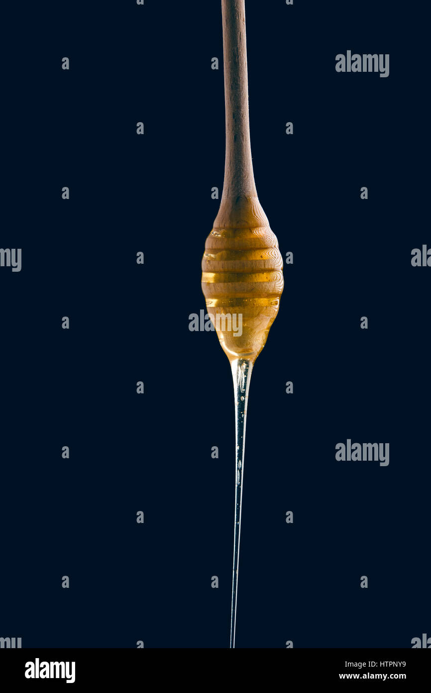 Honey stick on black background Stock Photo - Alamy