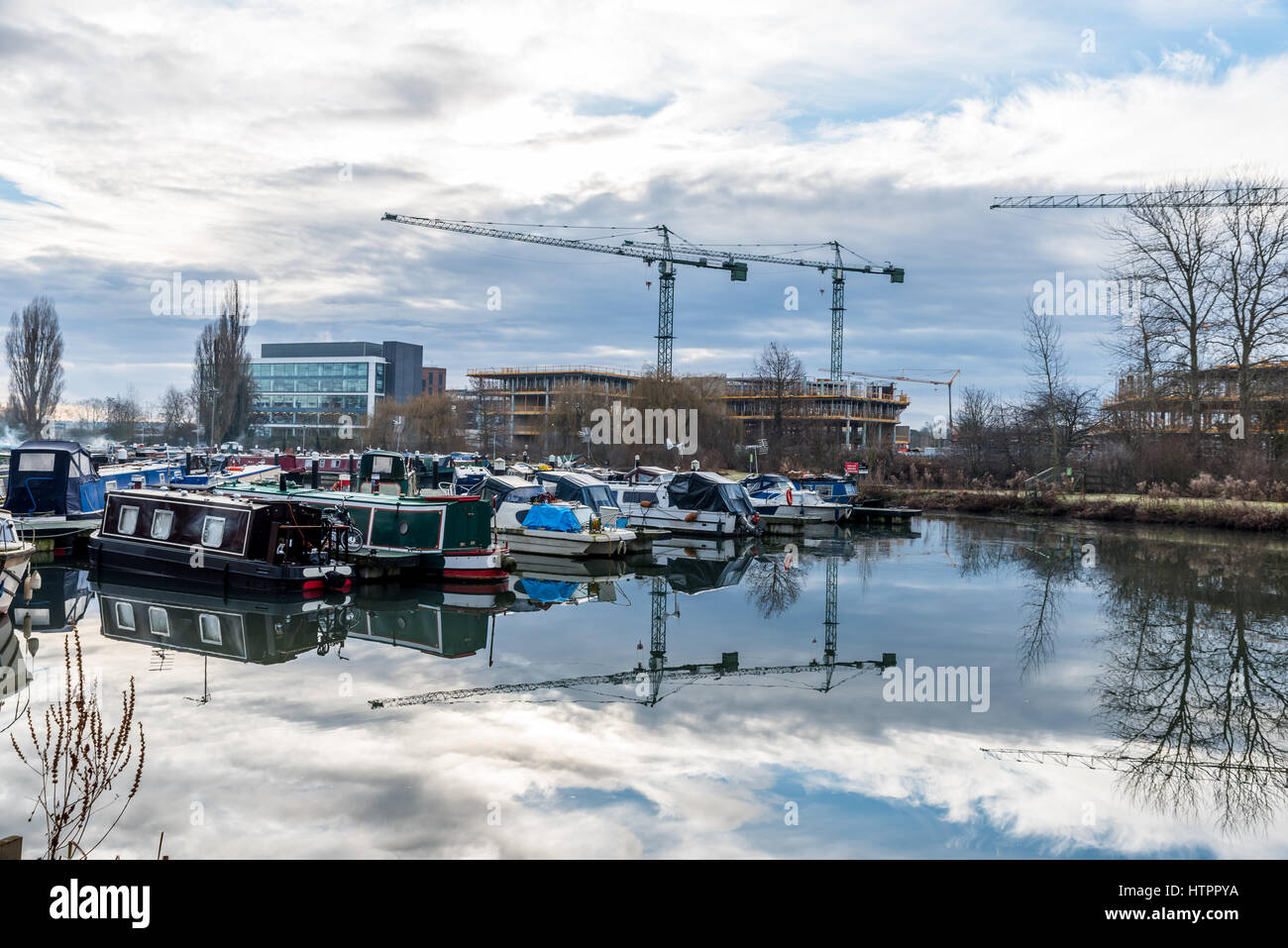 Boats parked at Marina in Northampton with construction cranes background. Stock Photo