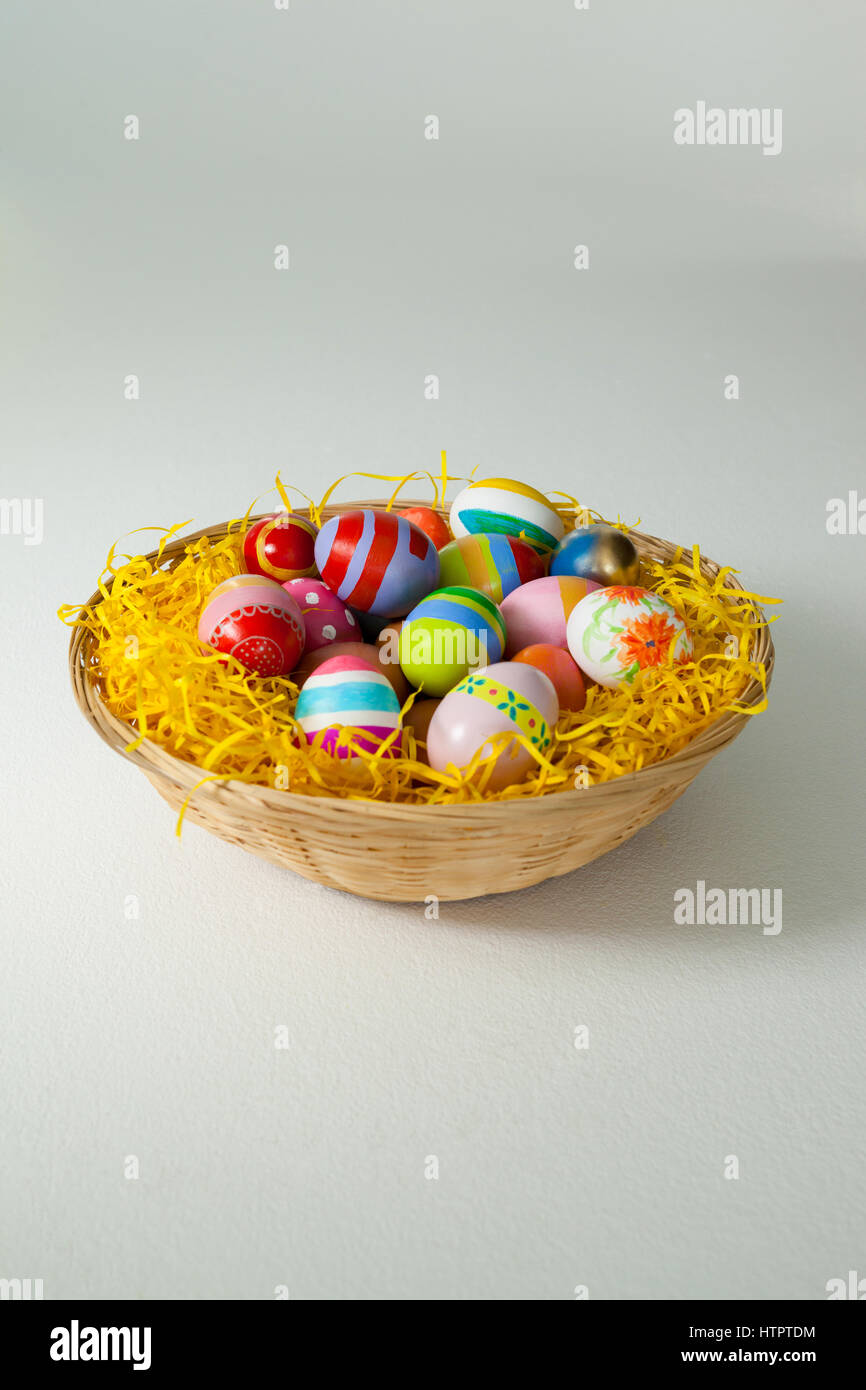 Painted easter eggs in basket against white background Stock Photo - Alamy