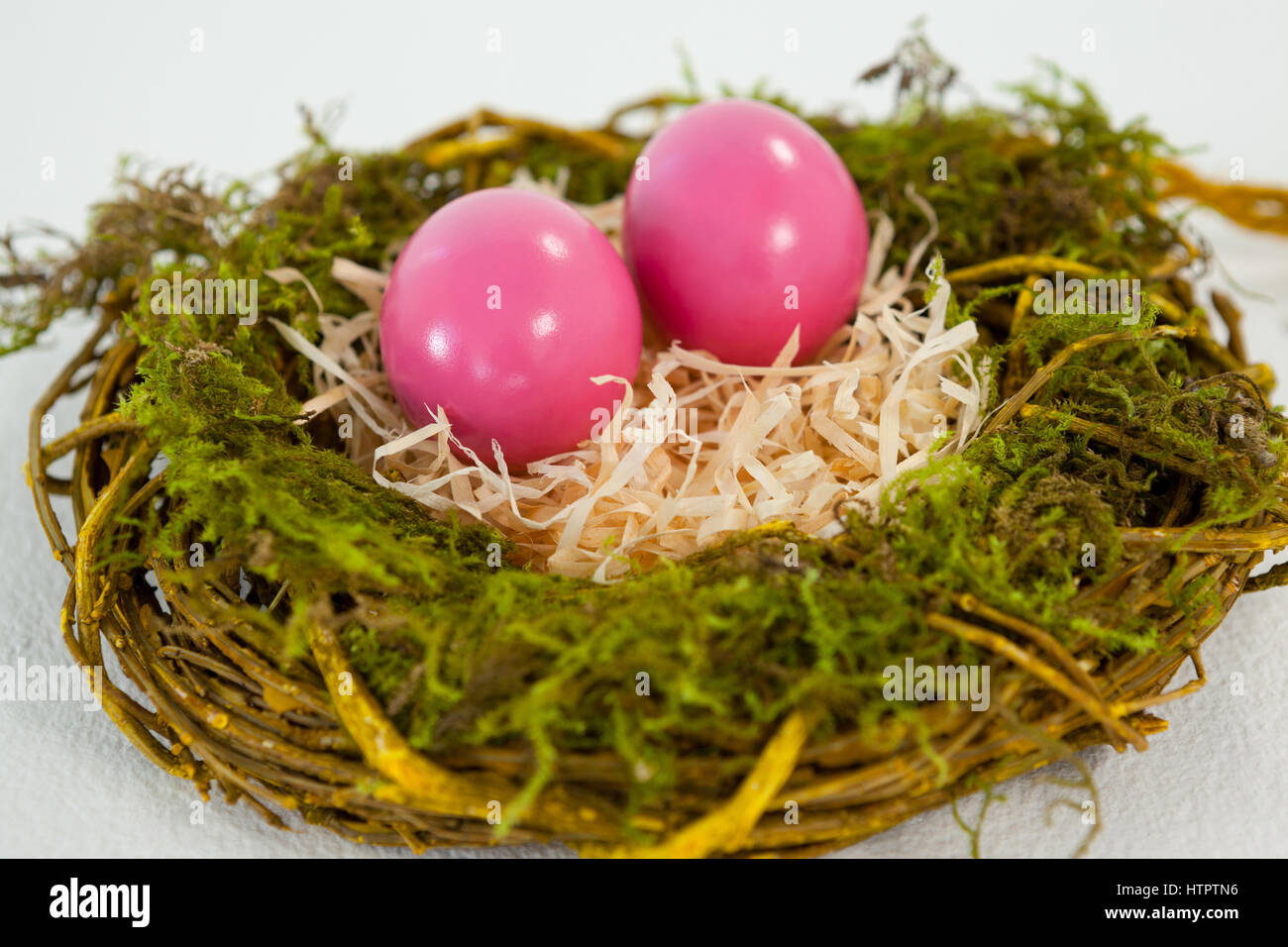Pink Easter eggs in the nest on white background Stock Photo - Alamy