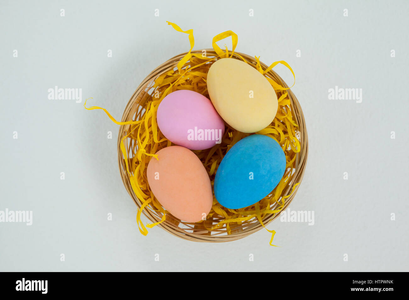 Painted easter eggs in basket against white background Stock Photo - Alamy