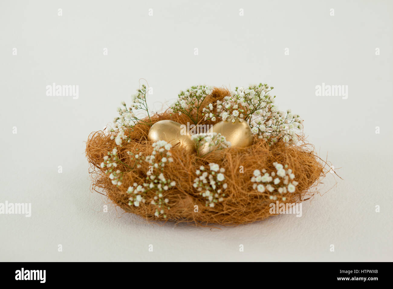 Golden easter eggs in nest against white background Stock Photo - Alamy